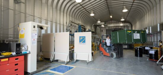 A worker operating a forklift inside a large licensed facility