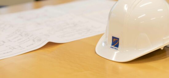 A hardhat and some design drawings on a table