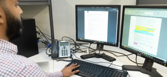 A person looking at data on computer screens