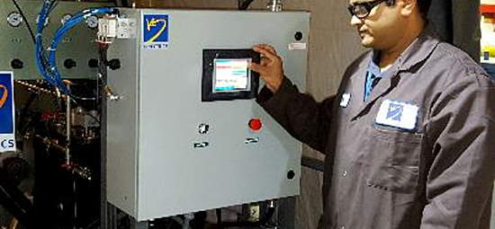 Photograph of a worker configuring a large machine via a touchscreen