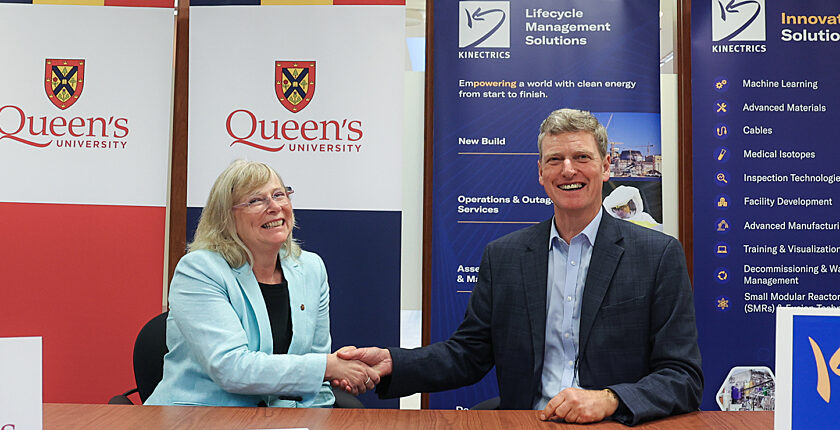 Kinectrics and Queen's University handshake after signing memorandum of understanding