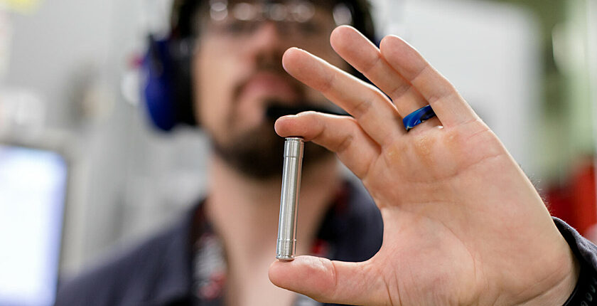 Closeup of a worker holding a target used in teh production of lutetium-177
