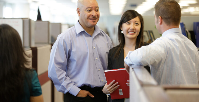 Workers chatting as a group in an office setting