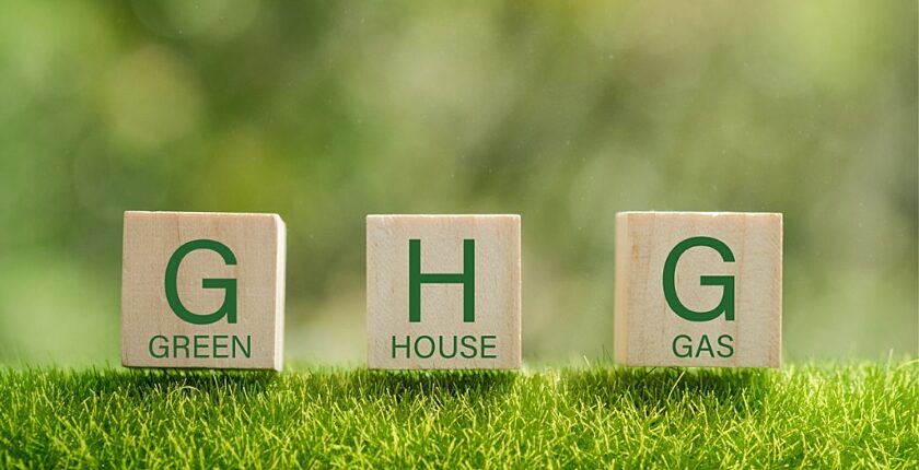 Abstract art of three scrabble game pieces in an outdoor setting that symbolizes green, house, and gas