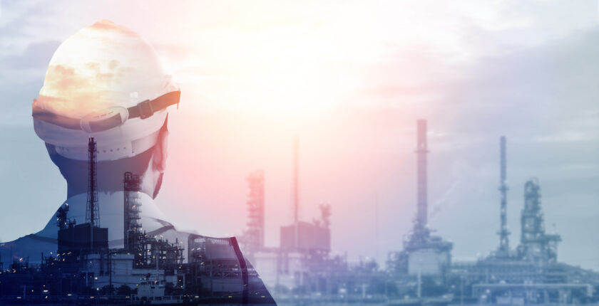 Abstract art of a transparent worker silhouette superimposed onto an industrial landscape