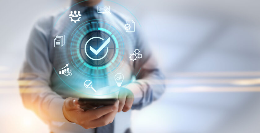 Abstract art of a worker holding a smartphone as hologram icons hover nearby