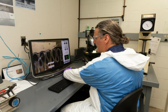 Worker examining material under a microscope