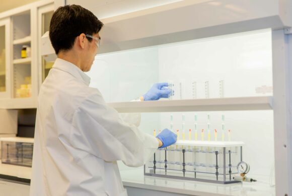 Worker examining test tubes filled with liquid