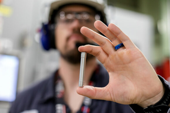 Closeup of a worker holding a target used in teh production of lutetium-177