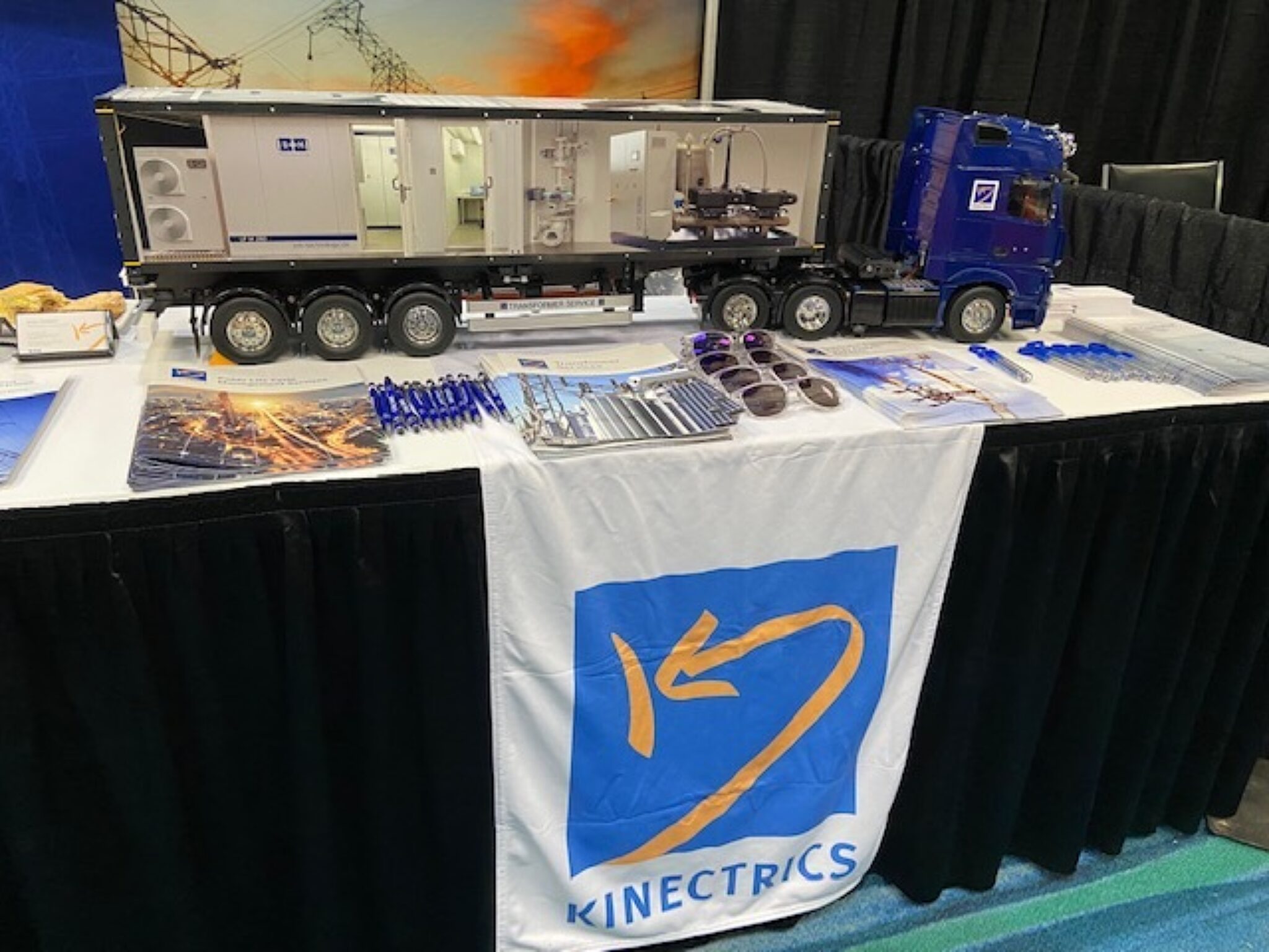 Photograph of Kinectrics' booth at the CAREC Conference & Exhibition, featuring a large scale-model truck