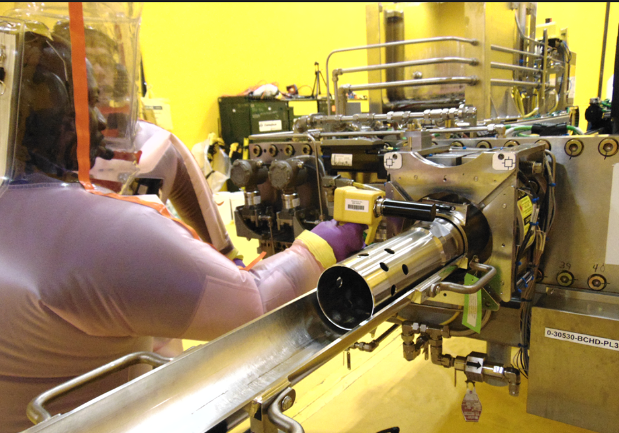 Worker performing maintenance on nuclear equipment Ontario Nuclear Services Facility