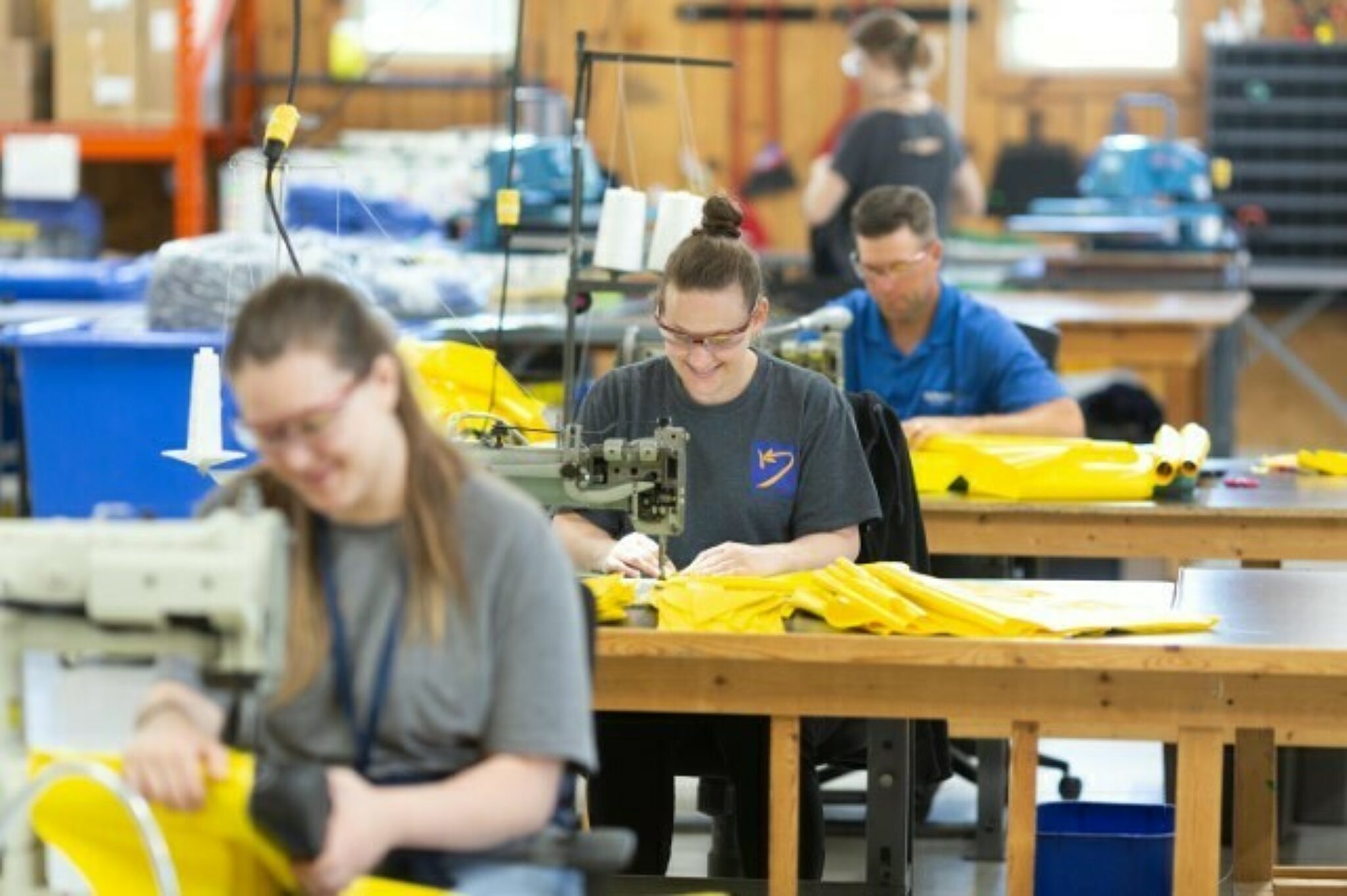 Kinectrics workers sewing together protective suits.