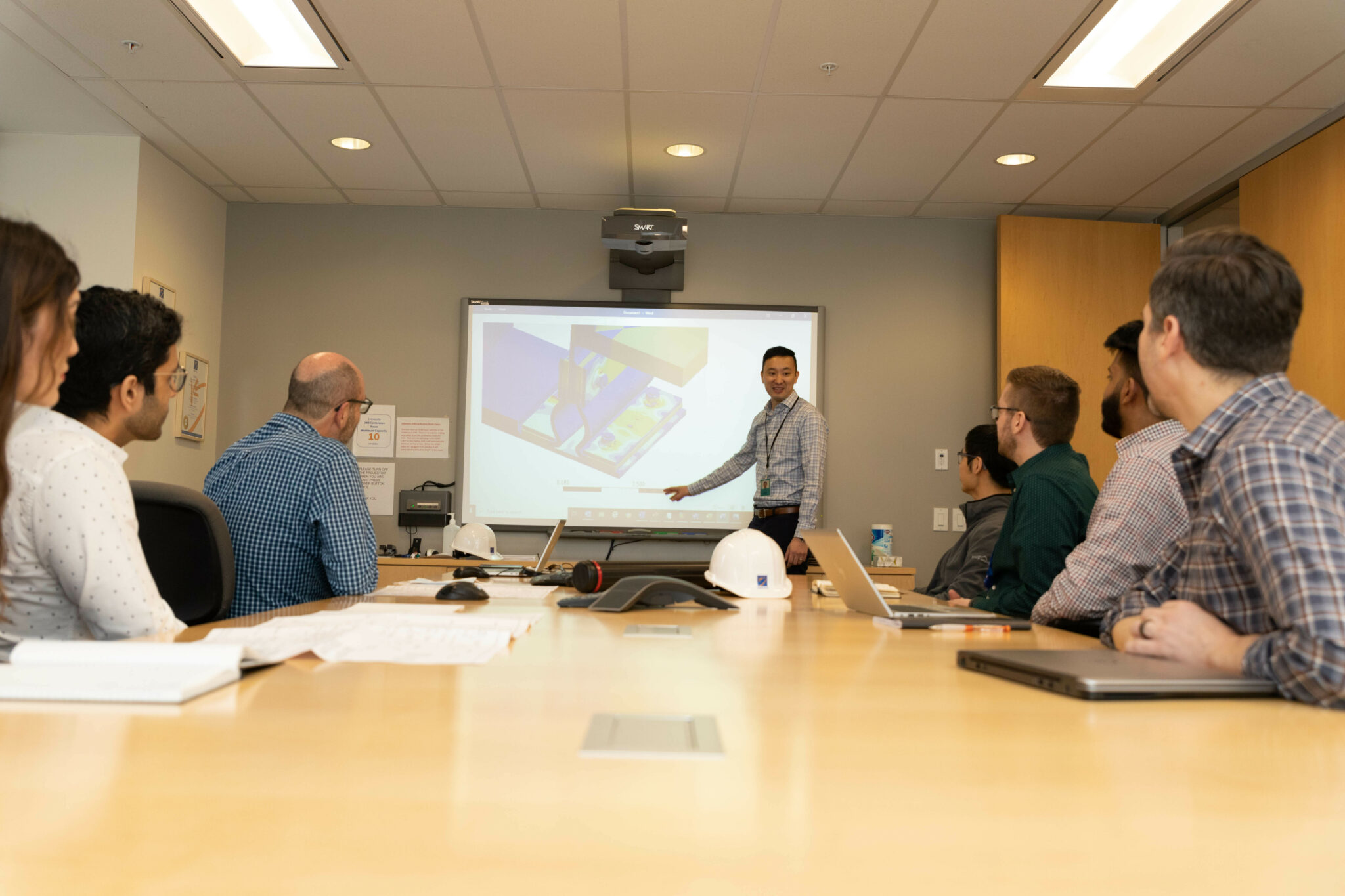 Worker presenting to a boardroom full of people