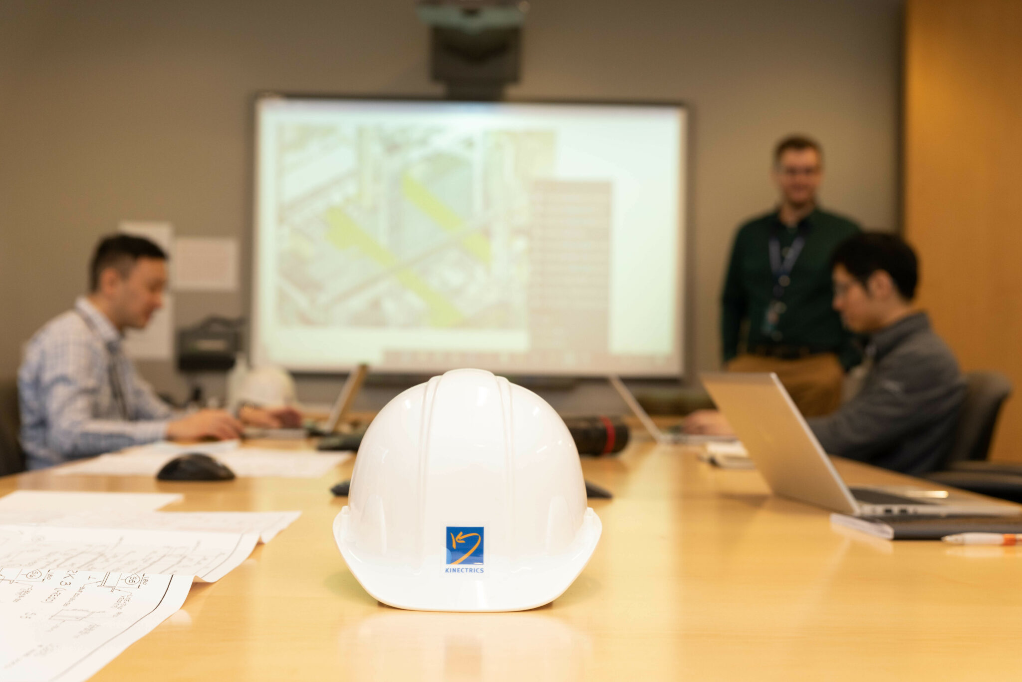Hardhat with Kinectrics logo on table in boardroom