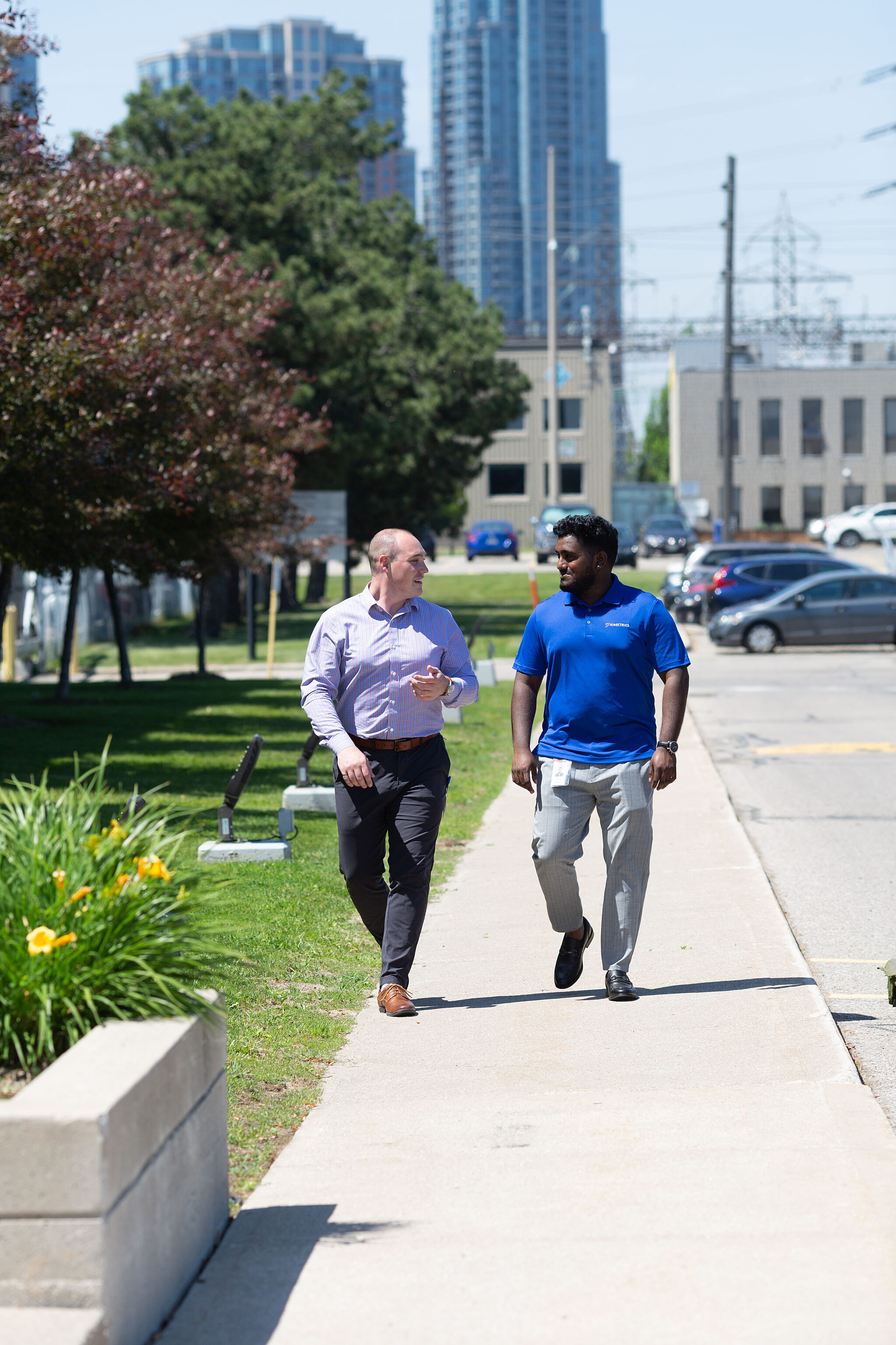 Outdoor photograph of two Kinectrics workers talking during a walk