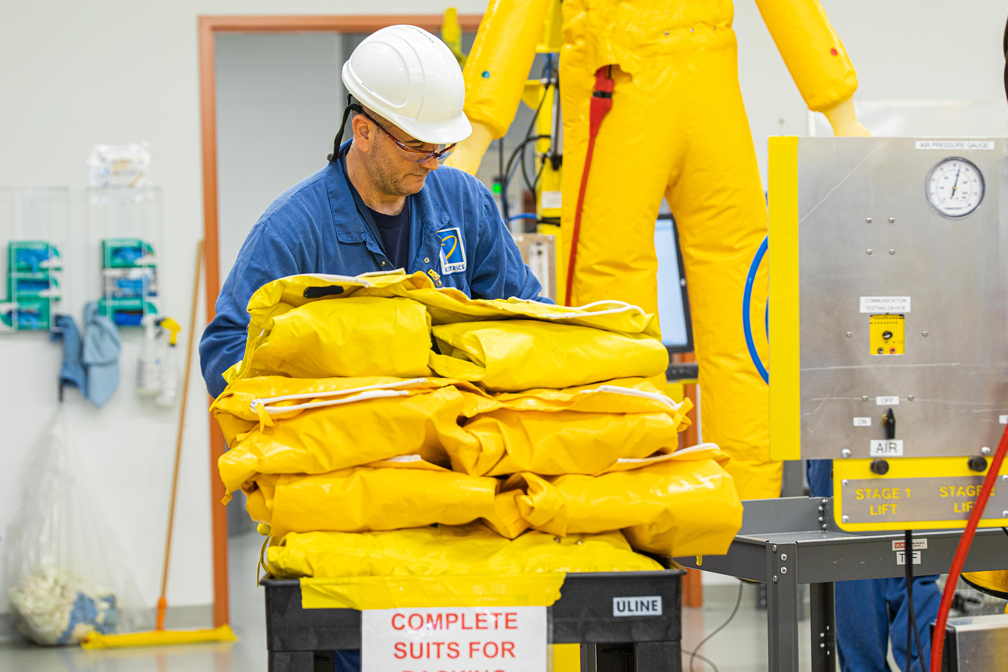Kinectrics worker carrying yellow protective suits