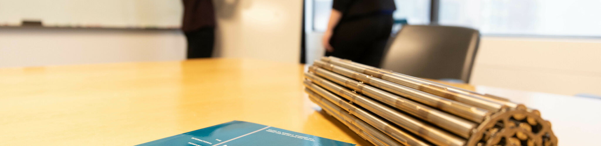 Closeup of a CANDU fuel bundle alongside textbook on a desk