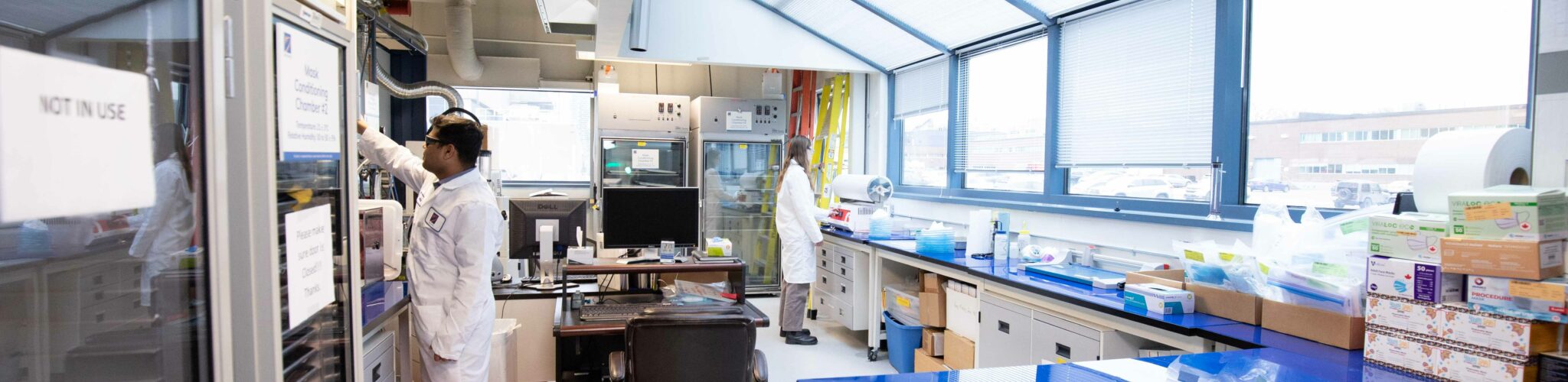 Workers performing tests in Kinectrics' mask testing facility