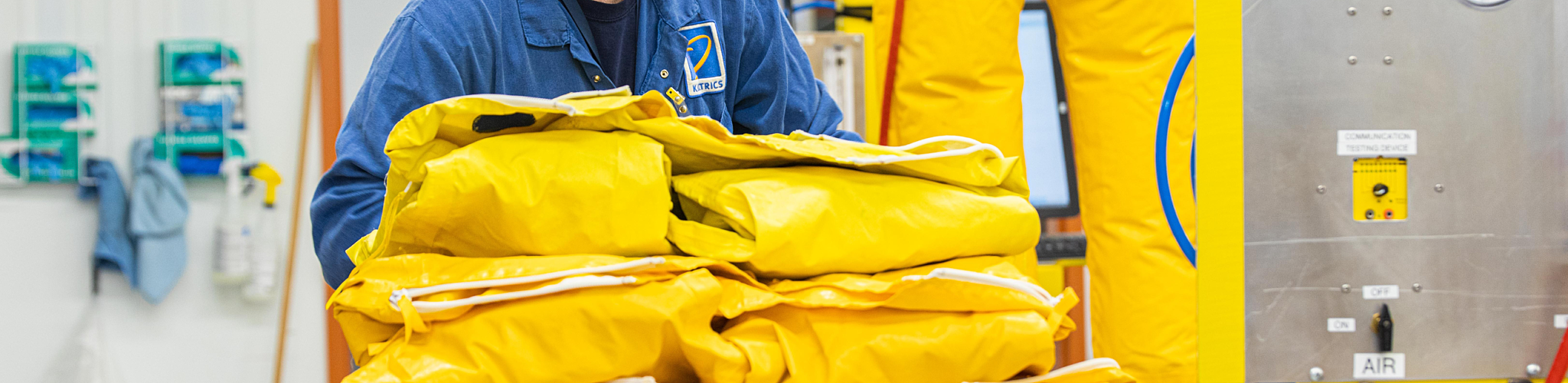 Kinectrics worker carrying yellow protective suits